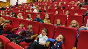 Dzieci z niecierpliwością czekają na rozpoczęcie spektaklu na widowni.