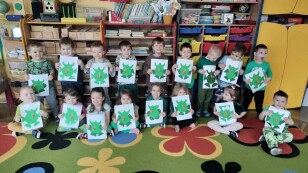 Dzieci z grupy 1 pozuja do zdjęcia z pracami plastycznymi - żabki