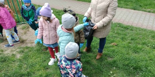 dzieci z grupy I i IV podczas akcji sprzątamy dla polski zbierają śmieci na pobliskim placu zabaw